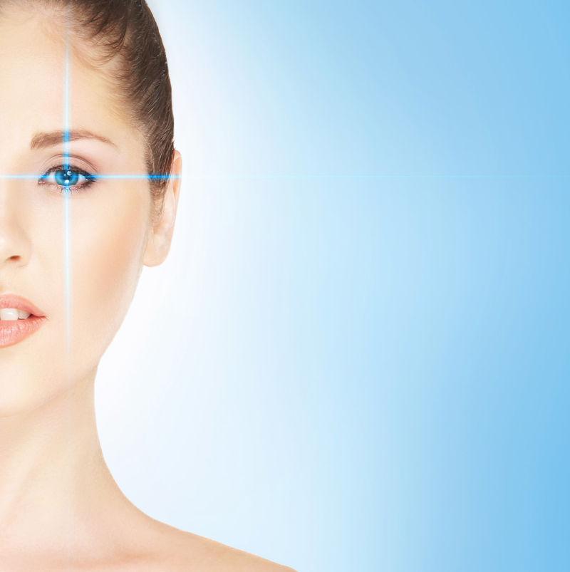 蓝色背景下年轻女人使用激光治疗近视