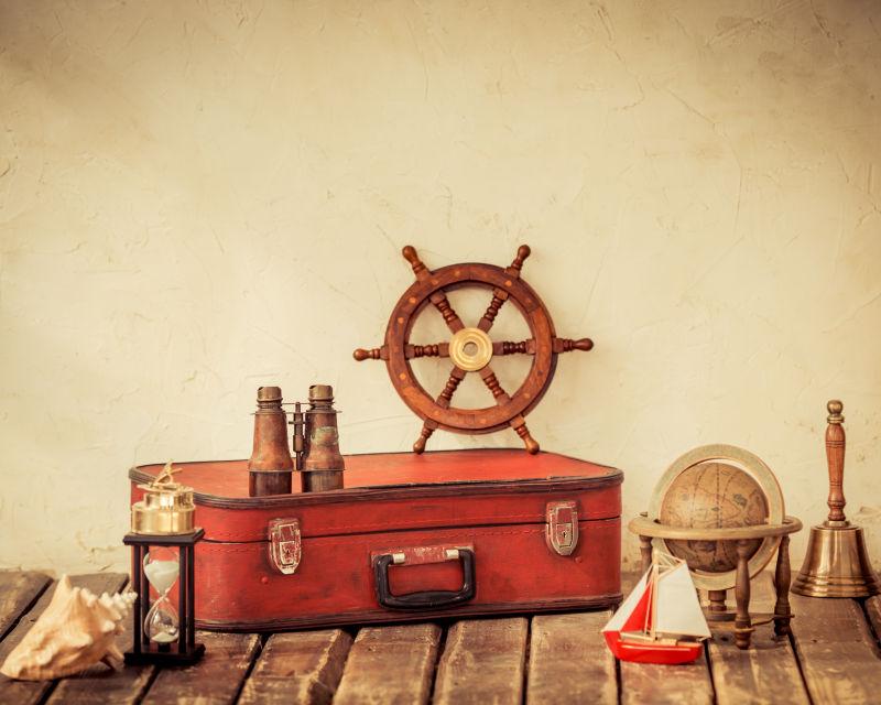 地板上的红色旅行皮箱和航海用品