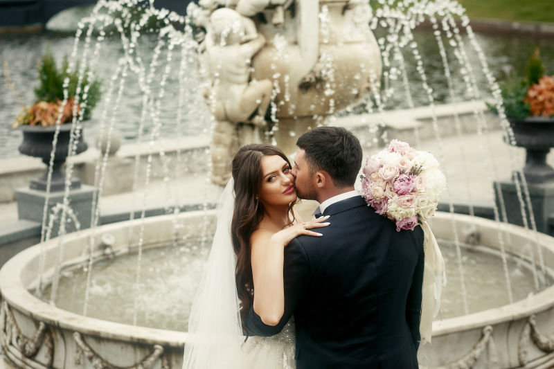 喷泉旁亲吻的新郎新娘