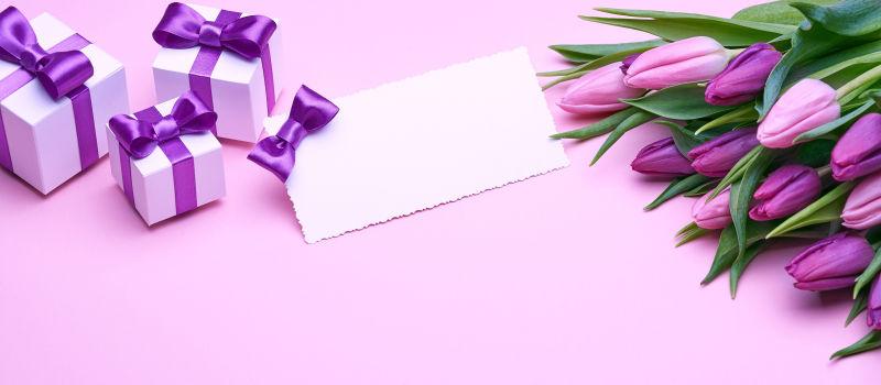 粉色背景中的郁金香卡片和礼物盒