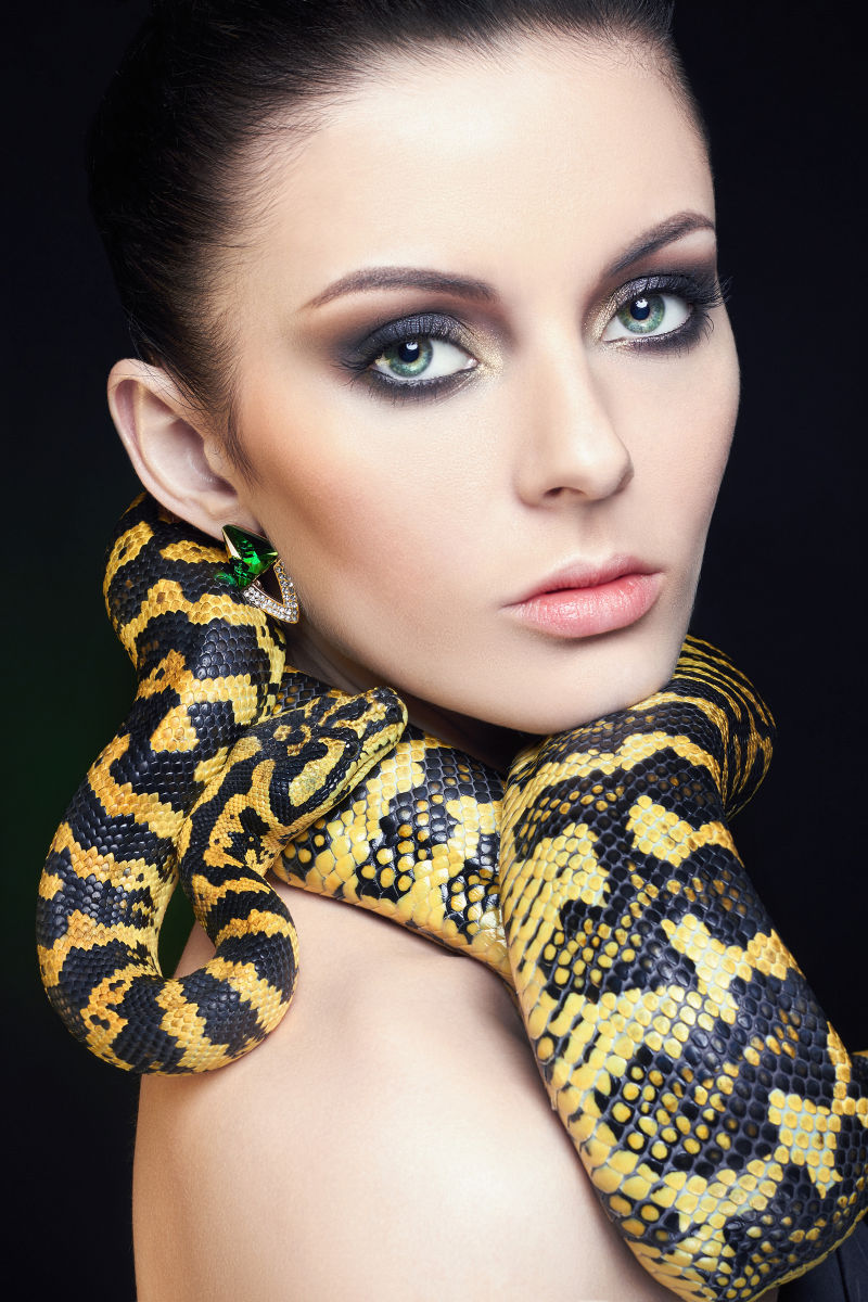 漂亮的年轻女人脖子上围着一条蛇
