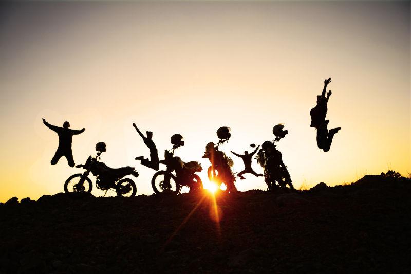 夕阳下的摩托车和一群欢快的人