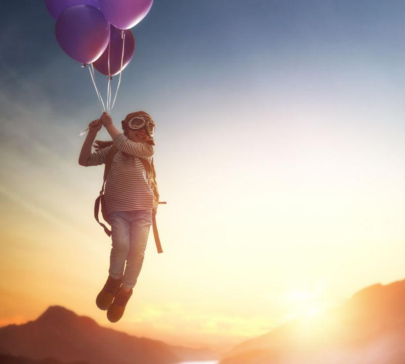在日落的背景下孩子们乘气球飞行的梦想