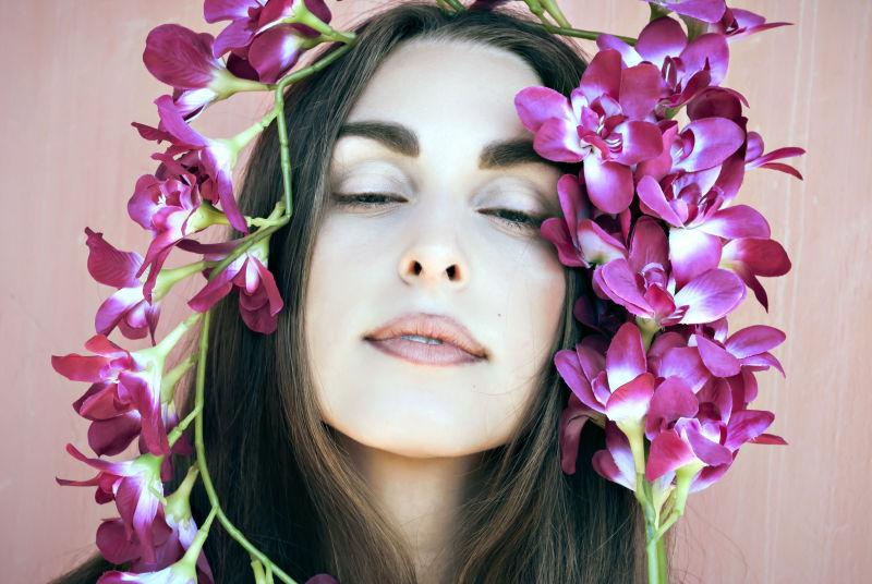 被紫色兰花包围的漂亮女孩