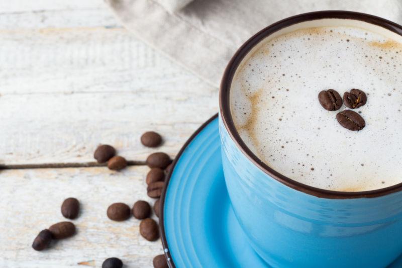 白木桌上的咖啡与咖啡豆