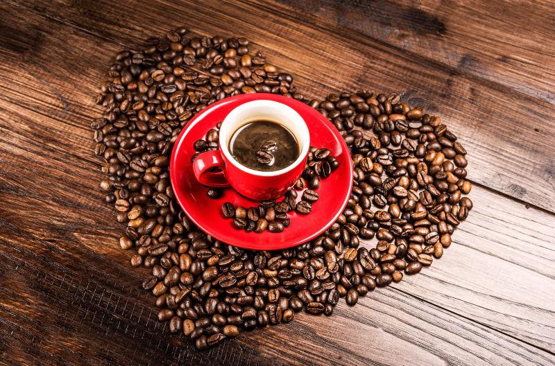 木桌上的心形咖啡与红色咖啡