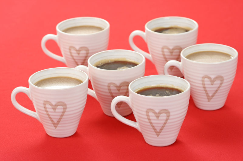 红色桌面上画着爱心的六个咖啡杯