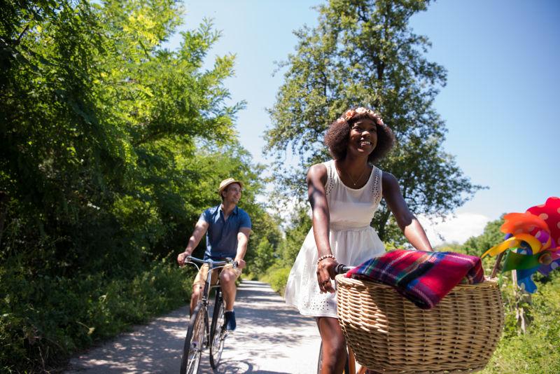 一个年轻人和一个美丽的非洲裔美国女孩骑着自行车