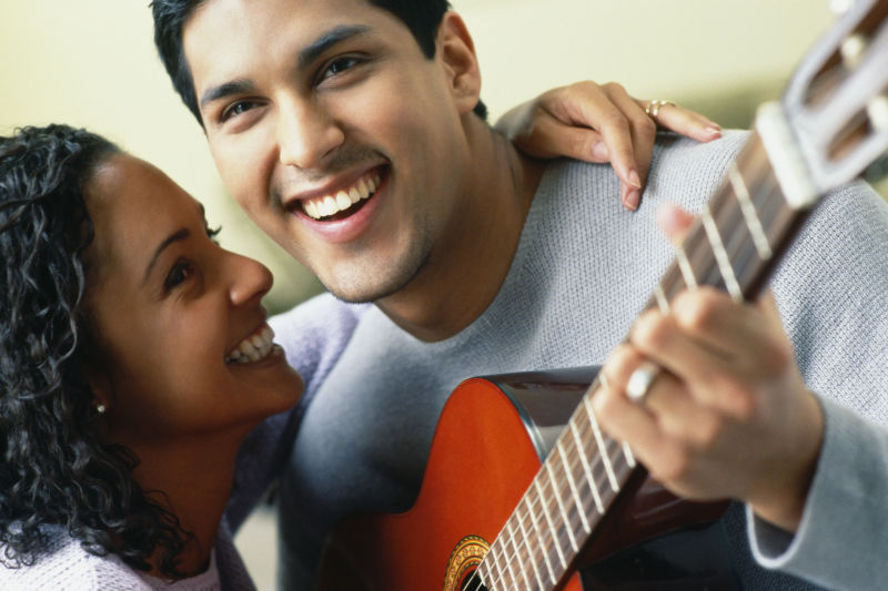 拥抱的西班牙情侣夫妇弹吉他