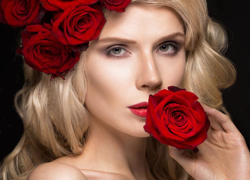 身着盛装的美丽金发女郎和红色玫瑰