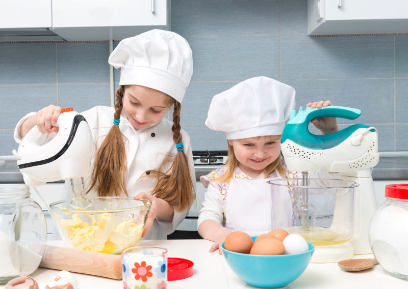 两个小女孩正在厨房里准备烹饪