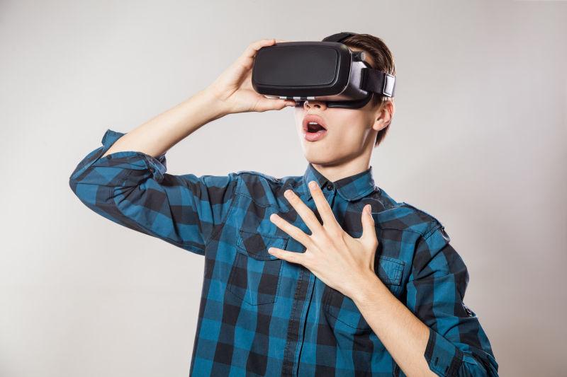 年轻男人戴着VR眼镜惊叹