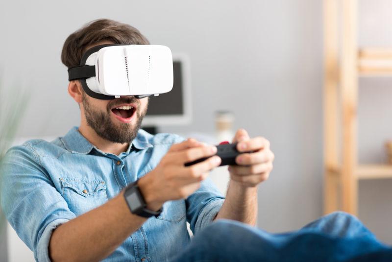 兴奋的戴着VR眼镜玩游戏的男人