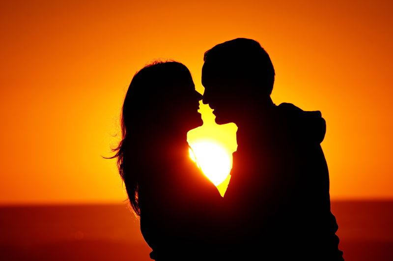 夕阳下海滩上的情侣剪影