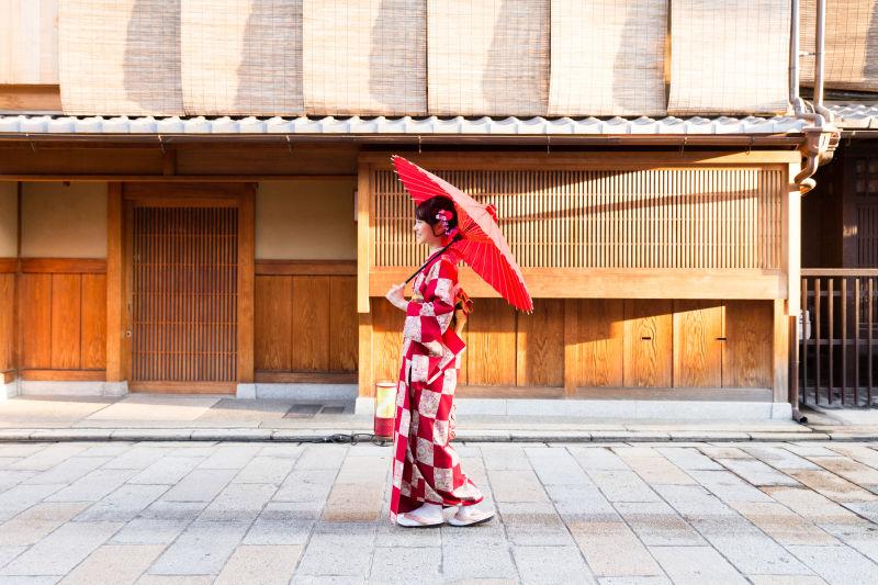 拿着伞走在街头的日本女人