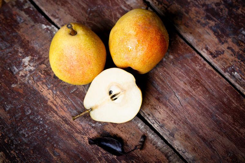 褐色木桌上被切开的成熟的梨