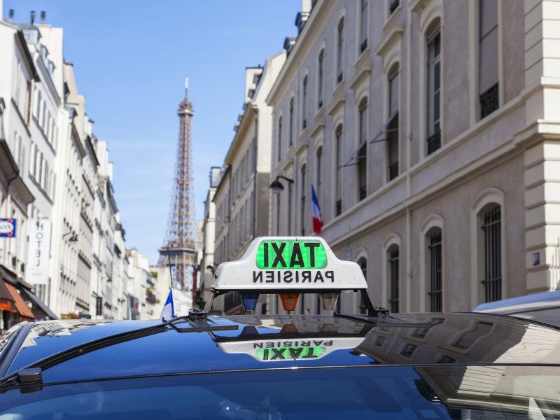 晴天下巴黎城市的埃菲尔铁塔前道路上的巴黎出租车