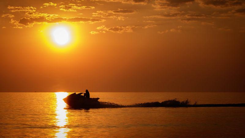 日落时分海面上的摩托艇