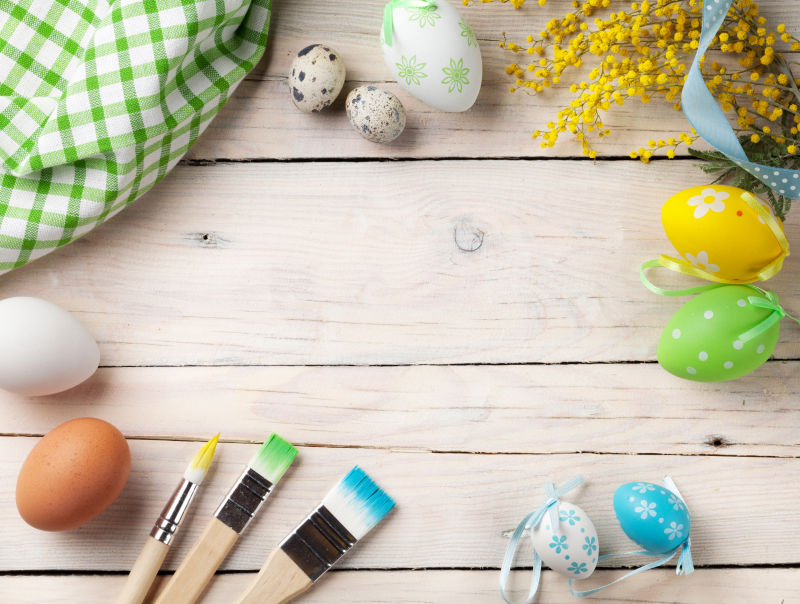 多彩的复活节彩蛋和木桌上的画笔