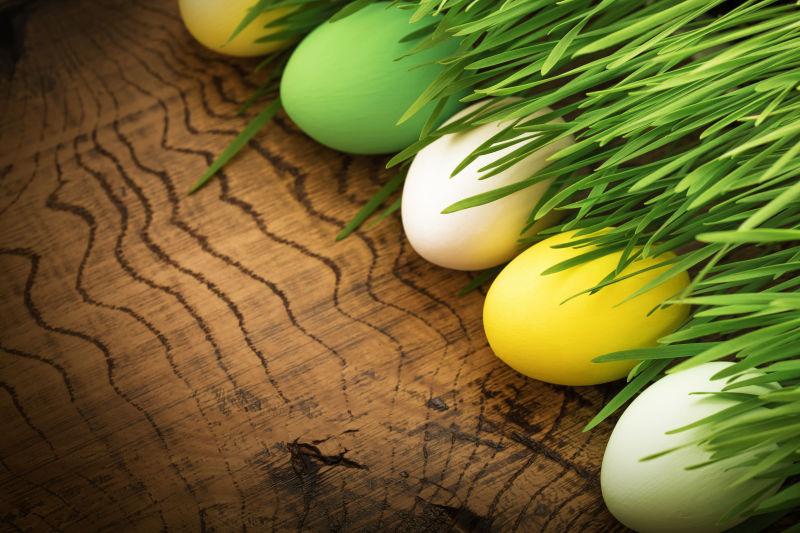 木桌上被绿色小草覆盖的复活节彩蛋