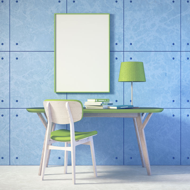 地板上的书桌和蓝色墙壁上的空白画框