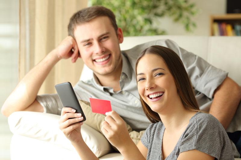 网上购买东西的夫妇用信用卡和智能手机