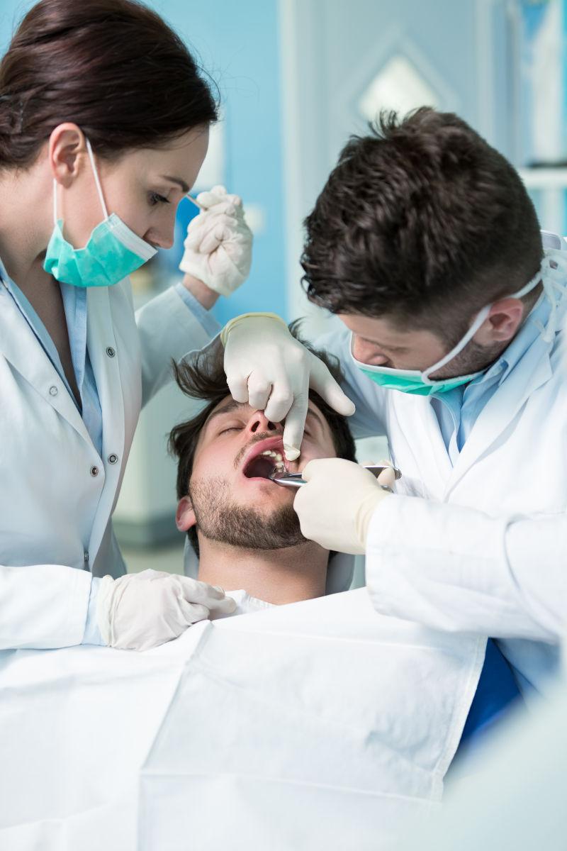 正在给病人检查牙齿的两个牙医