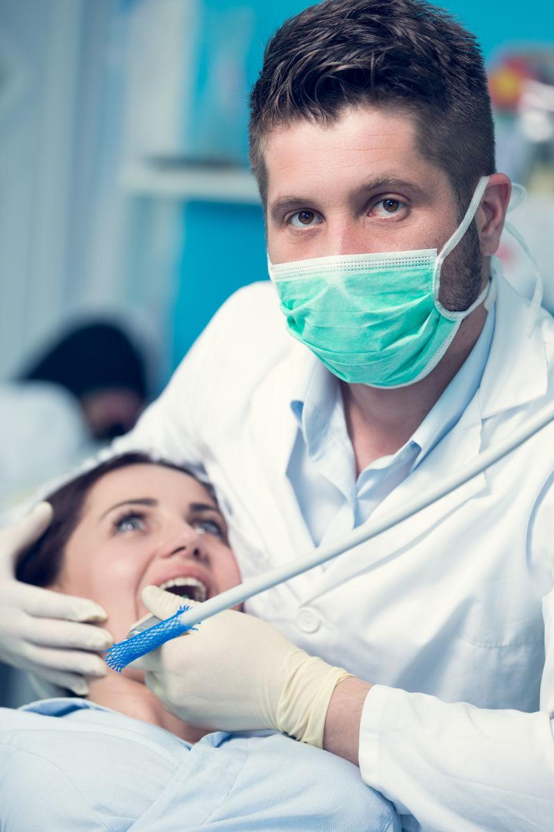 检查牙齿的男牙医和女病人