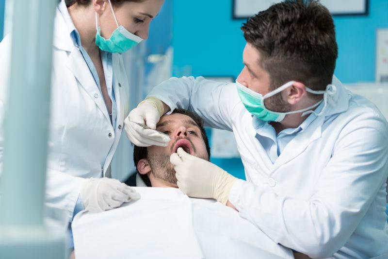 两个牙医正在给男病人检查