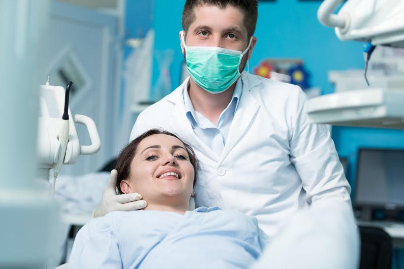 戴口罩的牙医和微笑的女病人