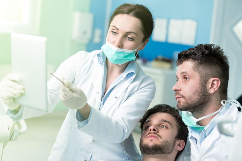 牙医拿着平板给病人讲解