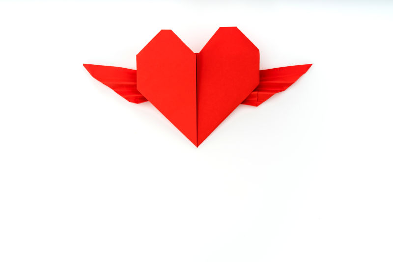 白色背景下带着翅膀红色心形折纸