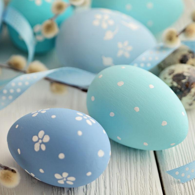 木纹理桌上蓝色带有小花朵的复活节彩蛋