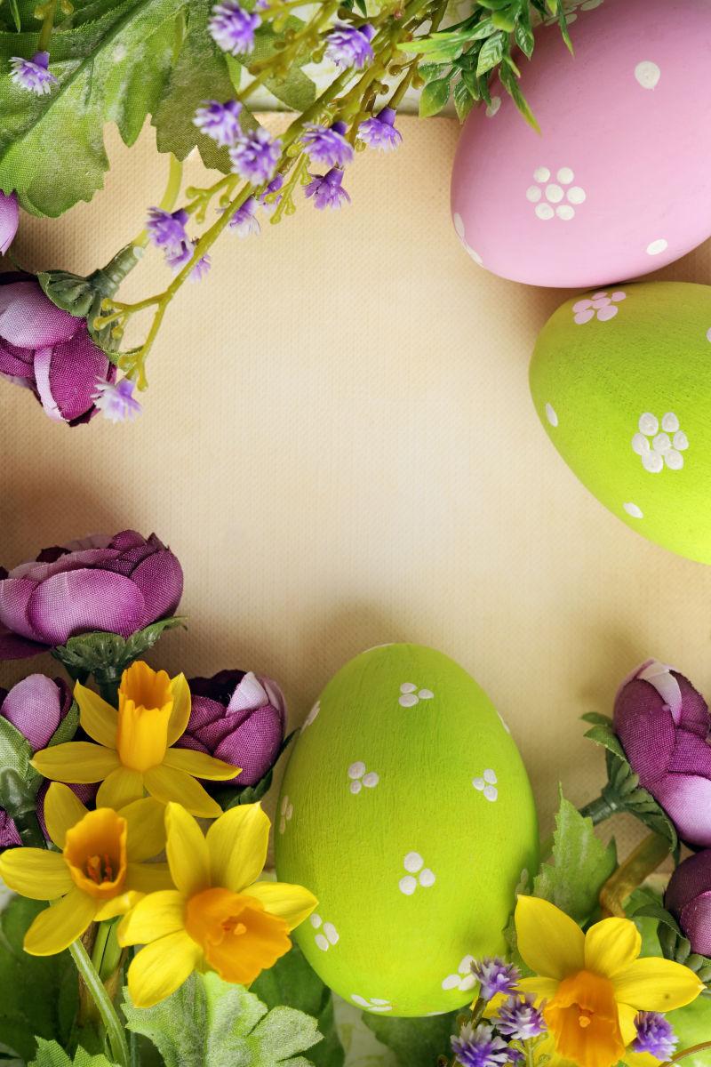 有花朵的黄色桌上的绿色和粉色的复活节彩蛋