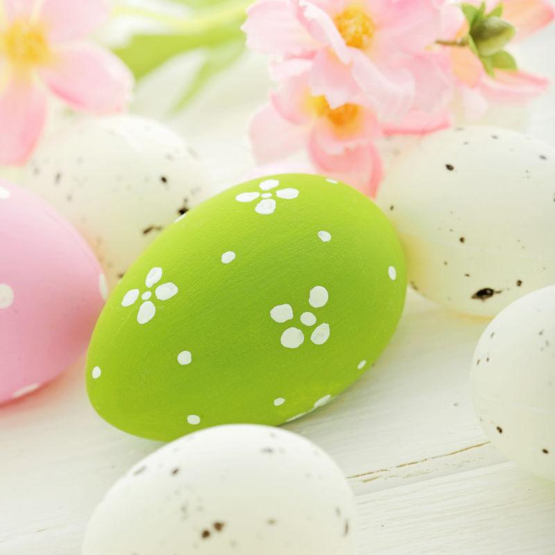 白色背景上的绿色和白色的复活节彩蛋