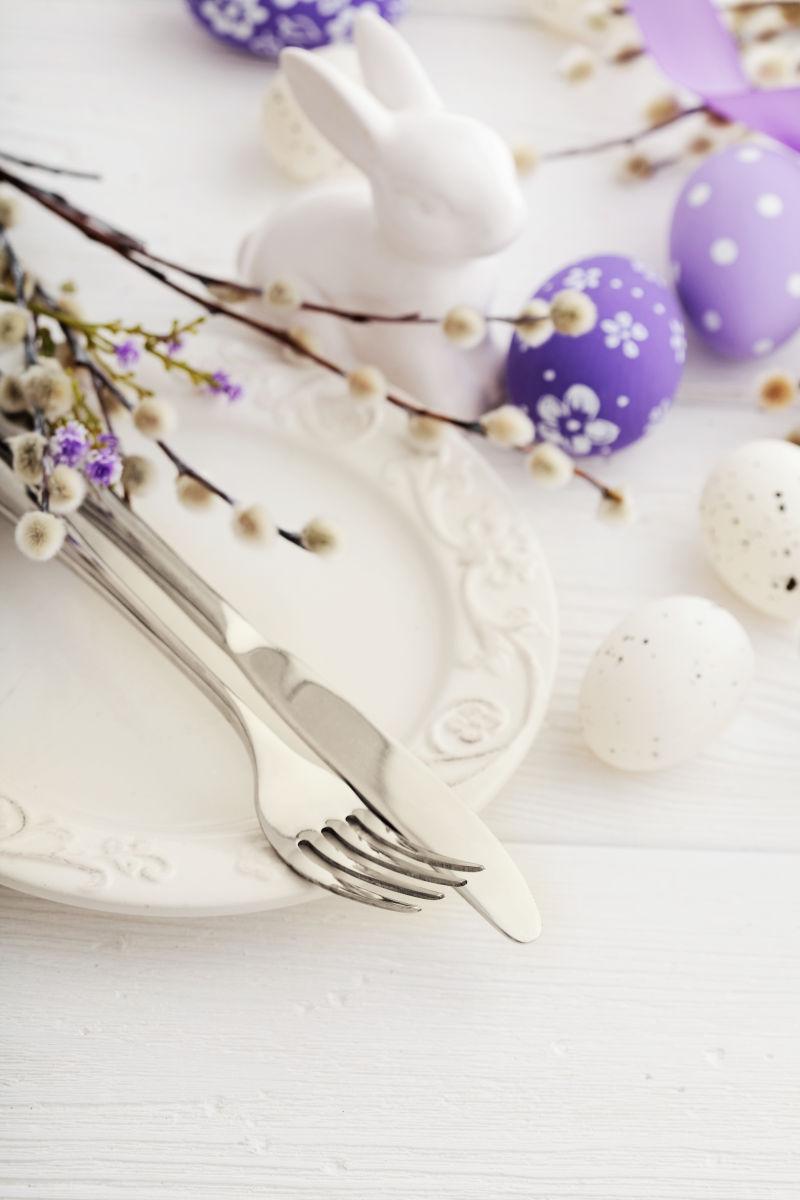 白色背景上的有复活节彩蛋的餐桌布置装饰