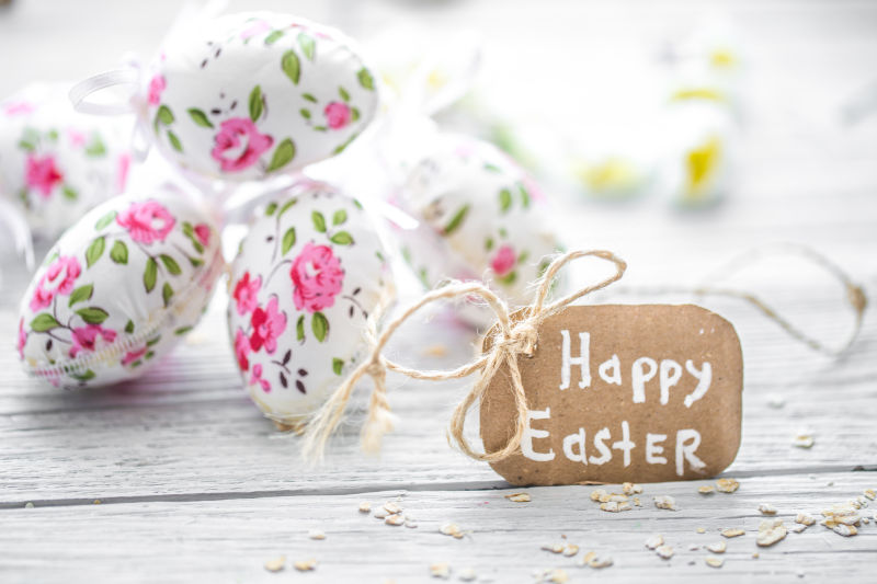 木桌上的复活节花朵彩蛋和祝福卡片