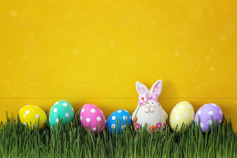 草坪上的复活节彩蛋与可爱的小兔子玩具
