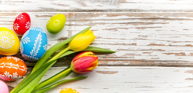 木桌上的黄色郁金香和复活节彩蛋