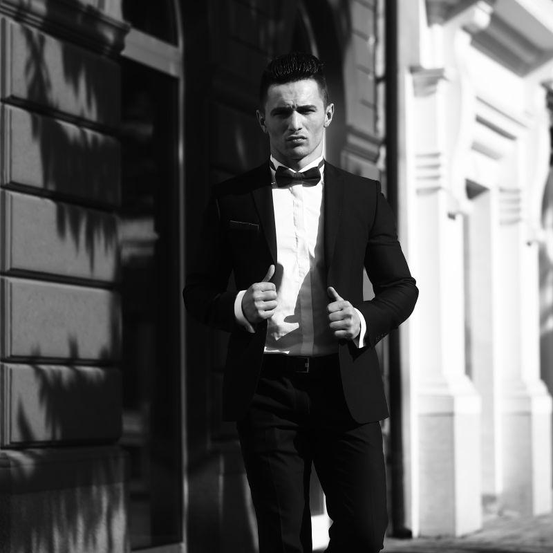 年轻帅气高雅的男子穿着西装领带在黑白相间的城市背景