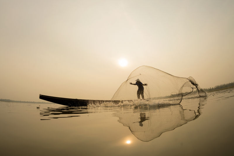 阳光下撒网捕鱼的渔夫