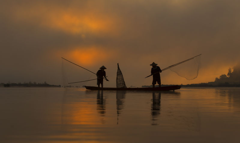 清晨撒网捕鱼的渔夫