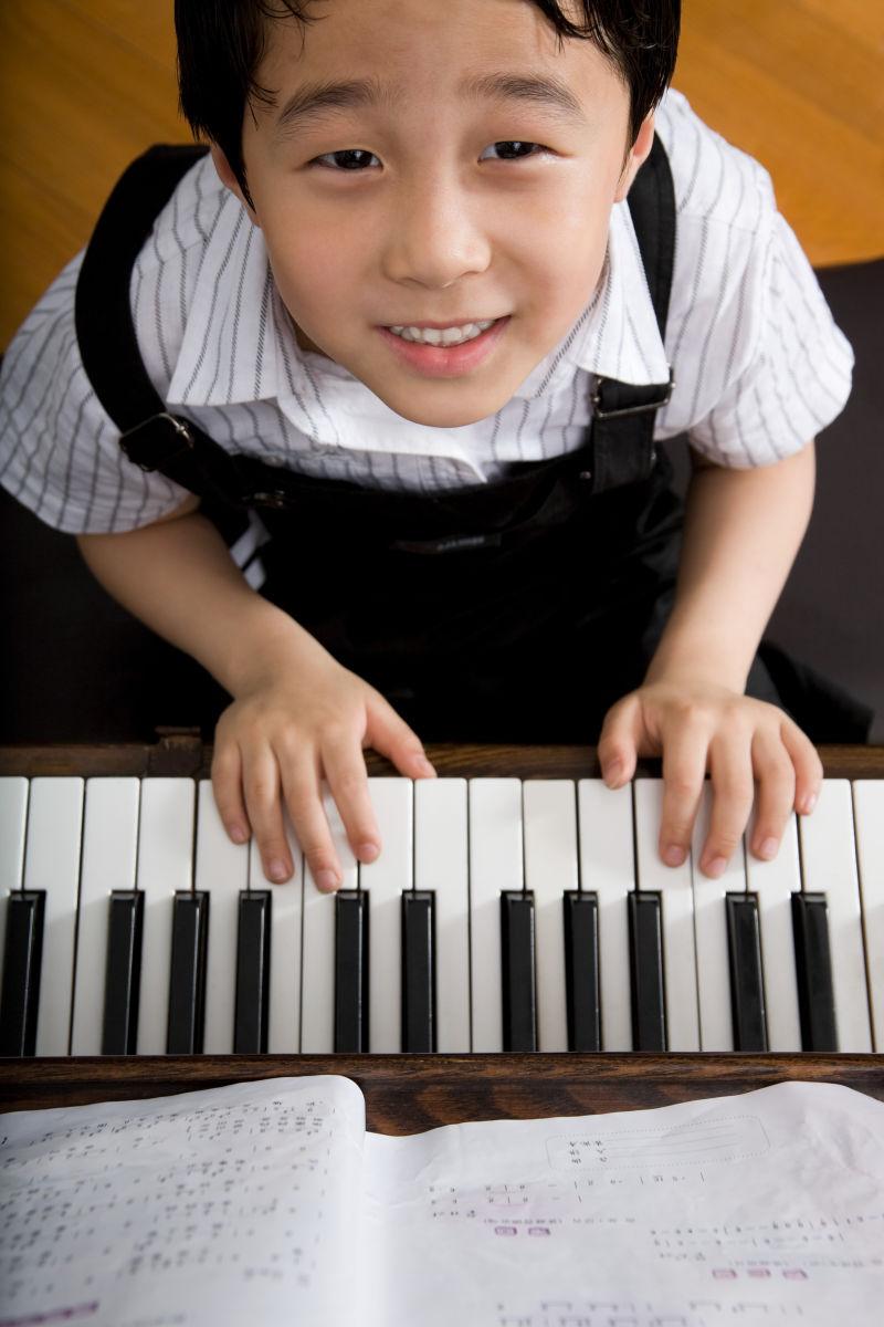弹钢琴的男孩抬头微笑