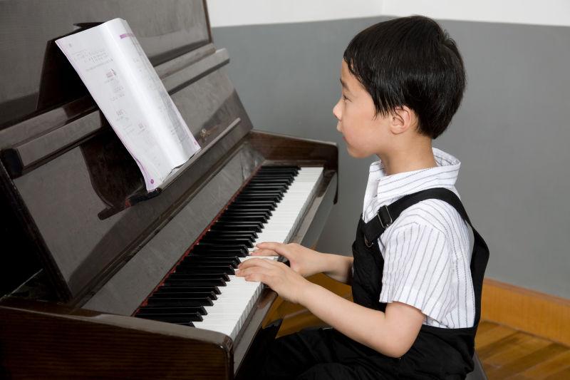 专心弹钢琴的男孩
