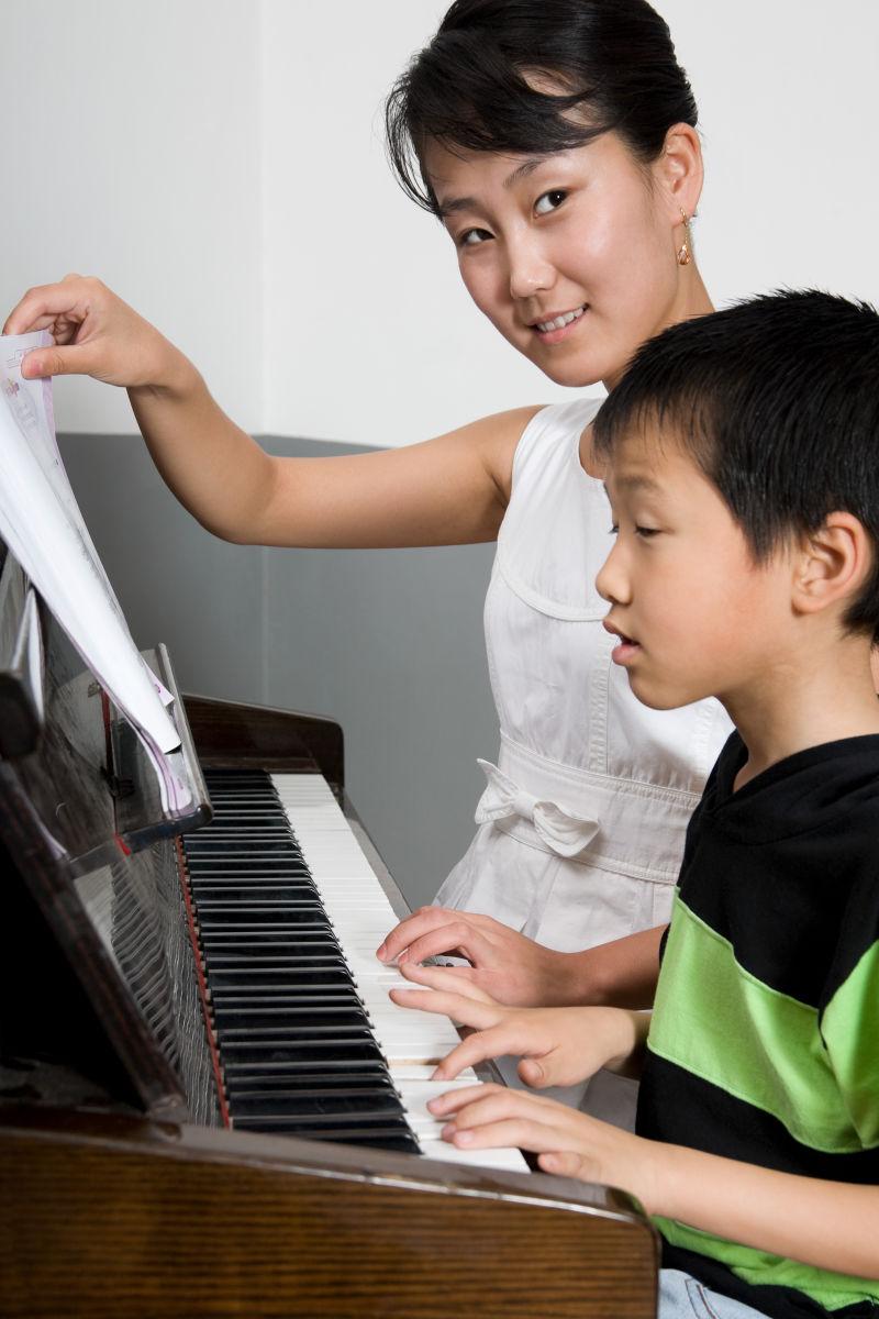 钢琴老师教学生学习钢琴