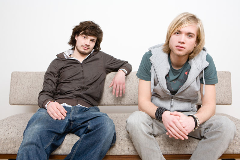 坐在沙发上的两个年轻男人