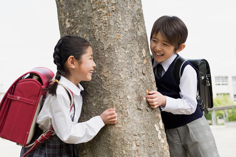 男孩和一个女孩在树旁