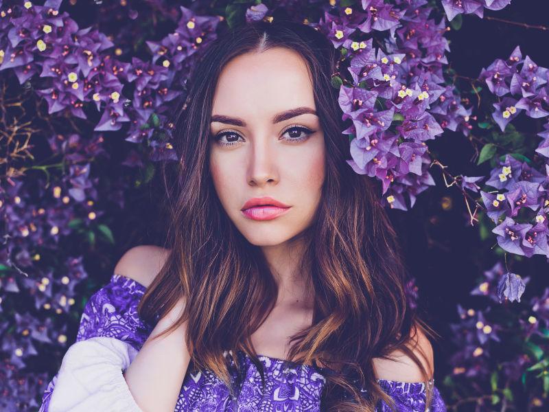 被紫色花朵包围挡住脸的美女