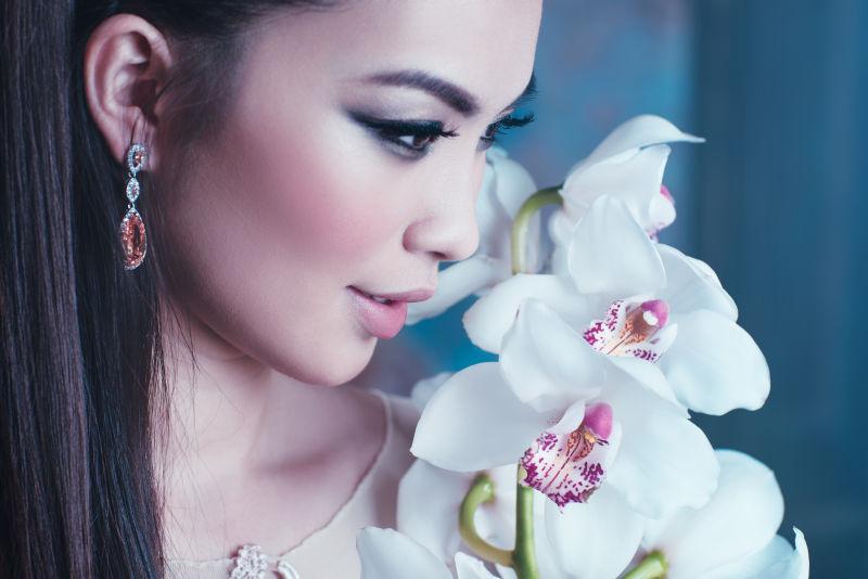 年轻的亚洲女子兰花花卉肖像特写