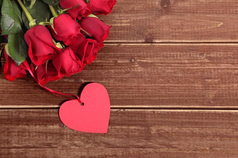 木板上的情人节红玫瑰和心形标签